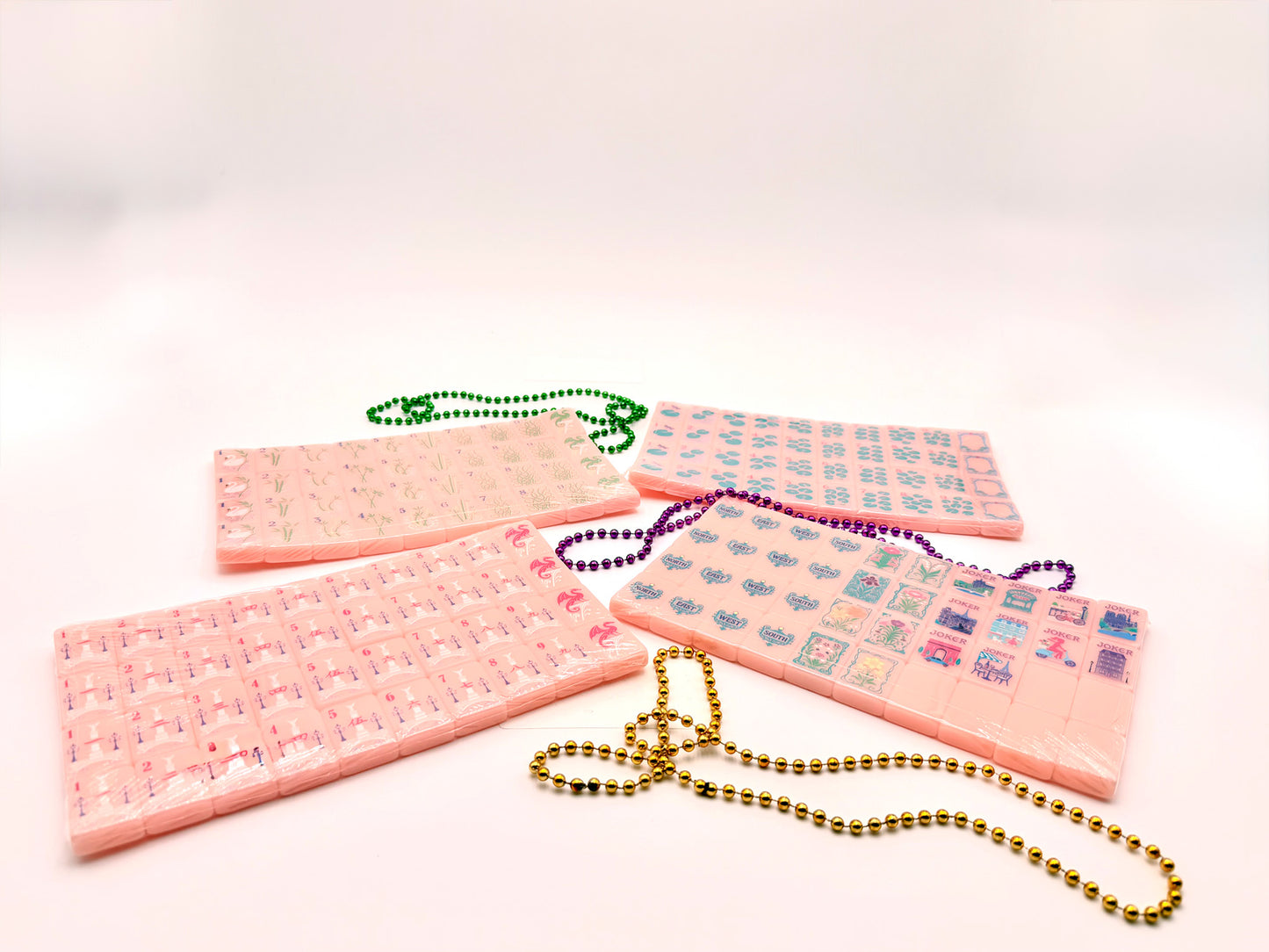 complete set of light pink acrylic mahjong tiles with colorful beads on a white background