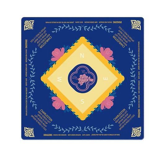 Decorative mahjong mat with floral design and compass rose on a blue background