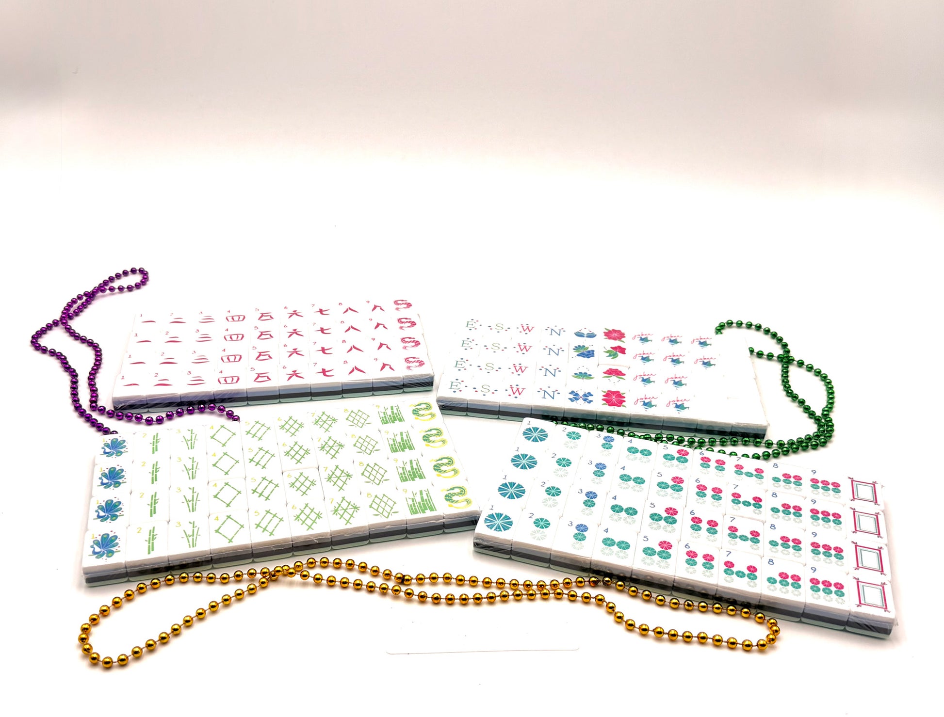 A set of acrylic mahjong tiles with beads and white background.