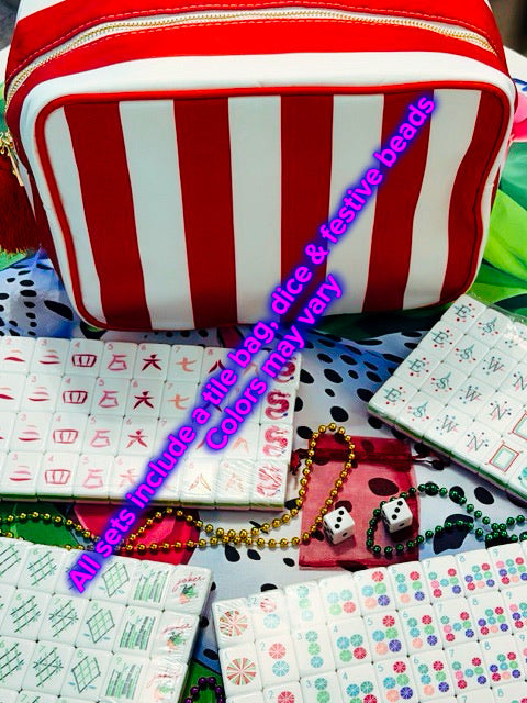 A red and white striped zippered file bag displayed with various mahjong sets, including tiles, dice, and bead necklaces, on a patterned fabric background. Purple text overlays describe the contents.