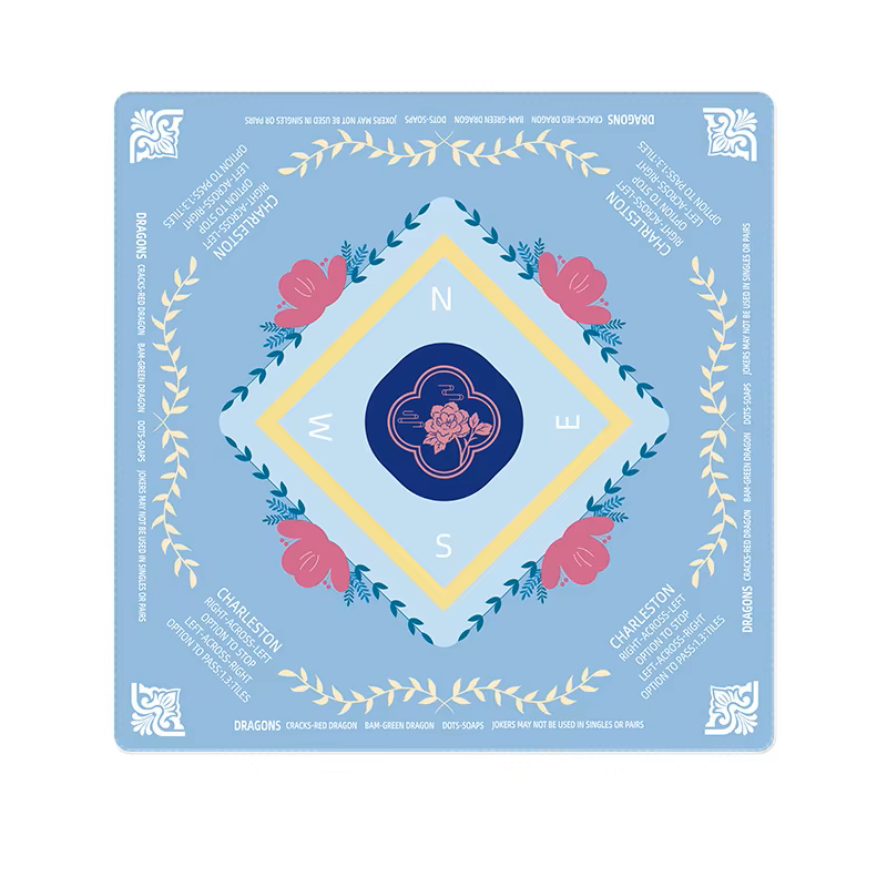 Decorative mahjong mat with floral elements and a central emblem on a blue background
